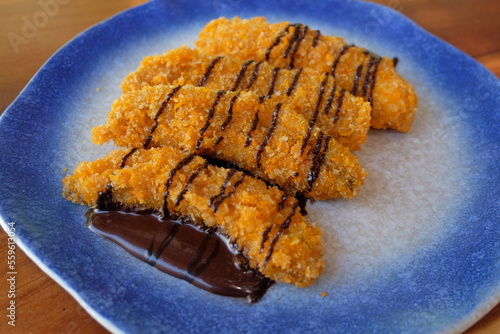 Crispy fried banana sprinkled with melted chocolate.