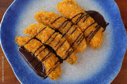 Crispy fried banana sprinkled with melted chocolate.