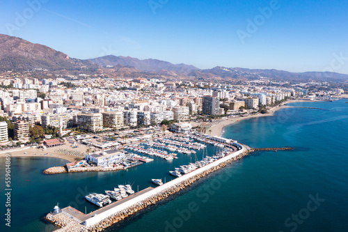 Picturesque autumn view from drone of coastal Mediterranean city of Marbella on background of mountain range overlooking sea harbour on summer day, Andalusia, Spain