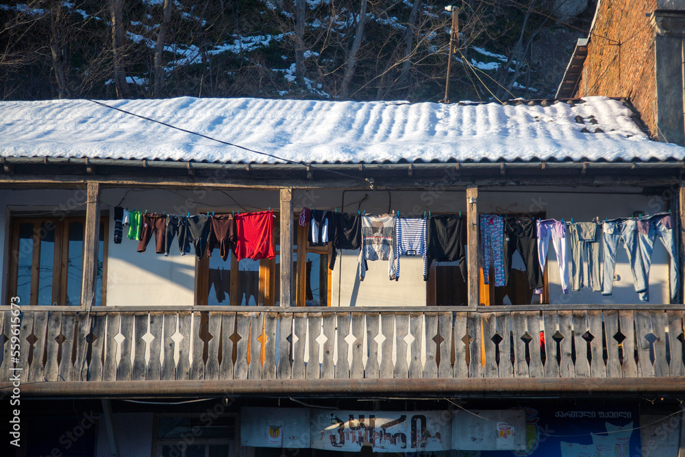 Washed clothes are drying on the balcony of an old traditional house