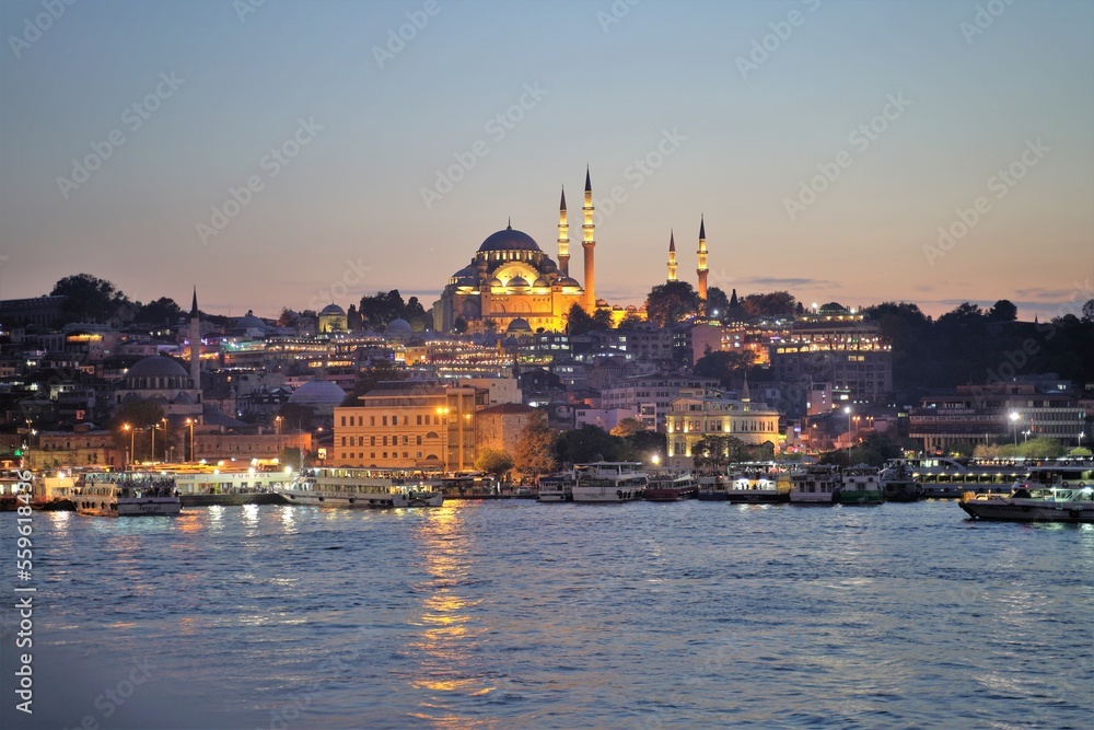 A cruise ship with the background of historic old Istanbul as the sun sets over the bosphorous straits in Istanbul, Turkey
