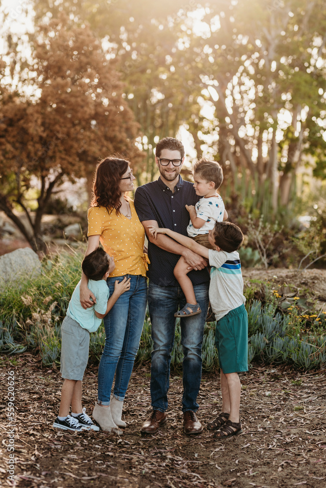 Portrait of family smiling at each other and hugging in cactus garden Portrait of family smiling at each other and hugging in cactus garden