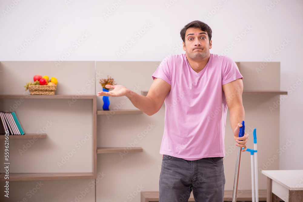 Young male contractor cleaning the house Young male contractor cleaning the house