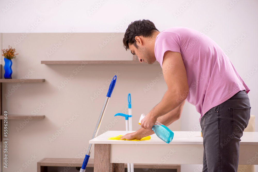 Young male contractor cleaning the house Young male contractor cleaning the house