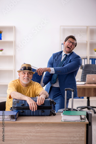Old male boss and young male employee in summer vacation concept