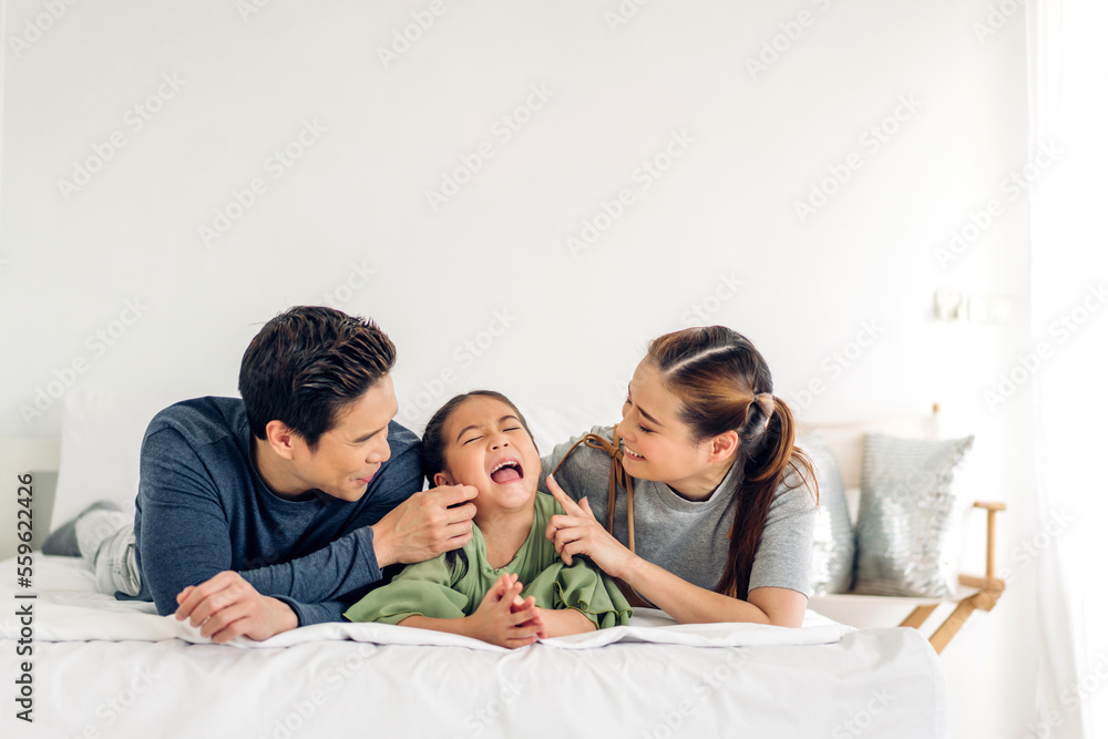 Portrait of enjoy happy love asian family father and mother holding hug cute little asian girl child smiling play and having fun moments good time in at home Portrait of enjoy happy love asian family father and mother holding hug cute little asian girl child smiling play and having fun moments good time in at home