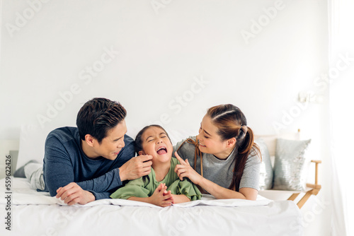 Portrait of enjoy happy love asian family father and mother holding hug cute little asian girl child smiling play and having fun moments good time in at home