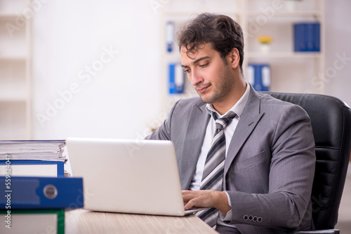 Young male employee unhappy with excessive work in the office