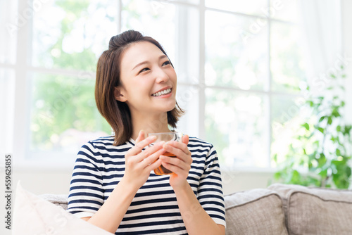 部屋でリラックスする若い女性 飲み物 Free Download 部屋でリラックスする若い女性 飲み物 - GFXLoad
