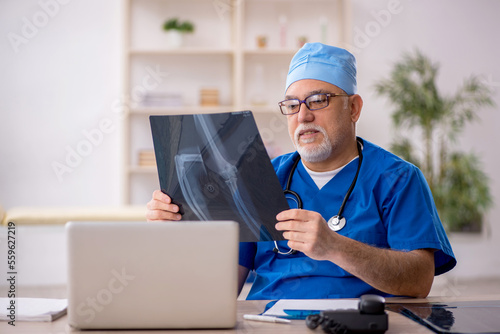 Old male doctor radiologist working in the clinic