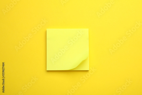 Paper note on yellow background, top view