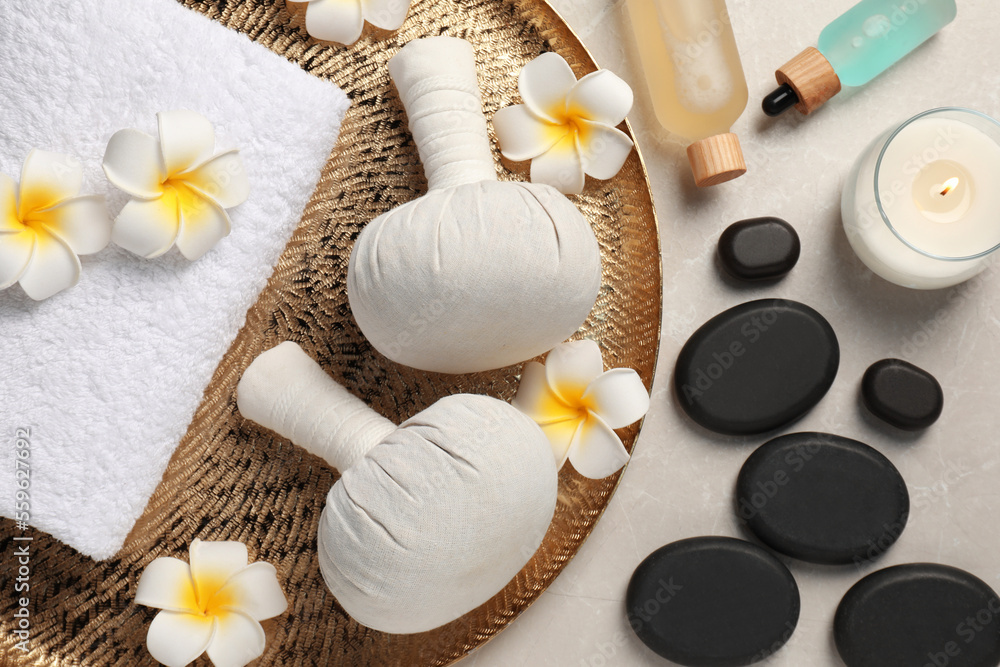 Spa bags, stones and orchid flowers on beige marble table, flat lay Spa bags, stones and orchid flowers on beige marble table, flat lay