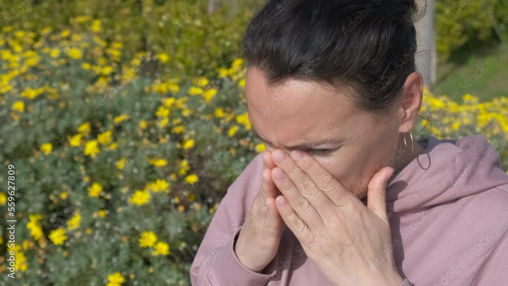 Seasonal allergies. The female in the spring park sneezes and feels discomfort. Seasonal allergies. The female in the spring park sneezes and feels discomfort.