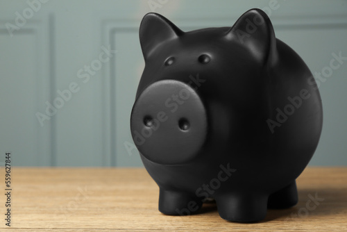 Ceramic piggy bank on wooden table, closeup. Space for text
