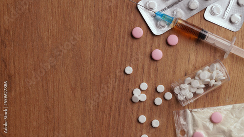 Different hard drugs on wooden table, flat lay. Space for text photo