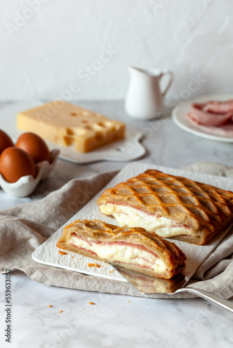 Puff with ham and cheese cut on a rectangular plate on a kitchen table