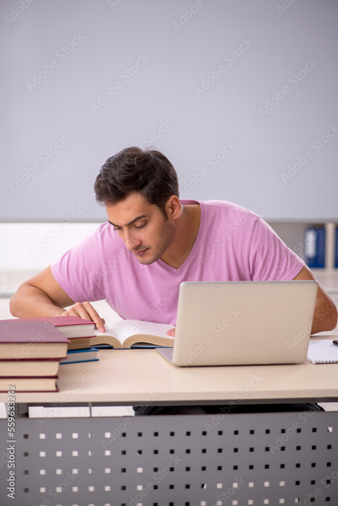 Young male student preparing for exams in the classroom Young male student preparing for exams in the classroom