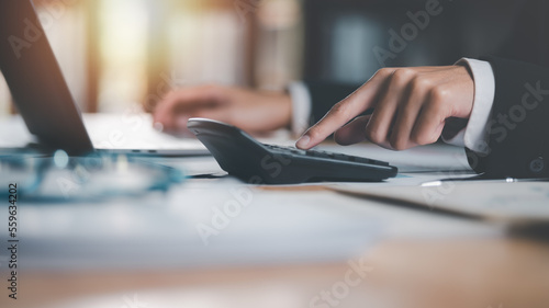 Fotografia Business people use calculator to calculate documents, profit and loss statement review concept of company performance, effective tax deduction planning for individuals and companies paying tax rates