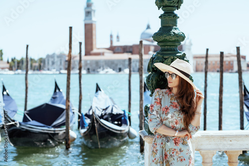 smiling elegant solo traveller woman in floral dress © Alliance