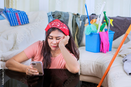 Εκτύπωση καμβά Bored maid using a cellphone at untidy living room