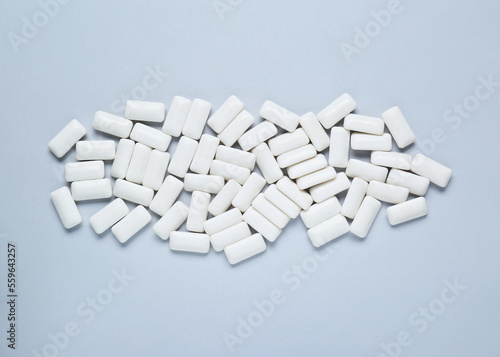 Tasty white chewing gums on light grey background, flat lay