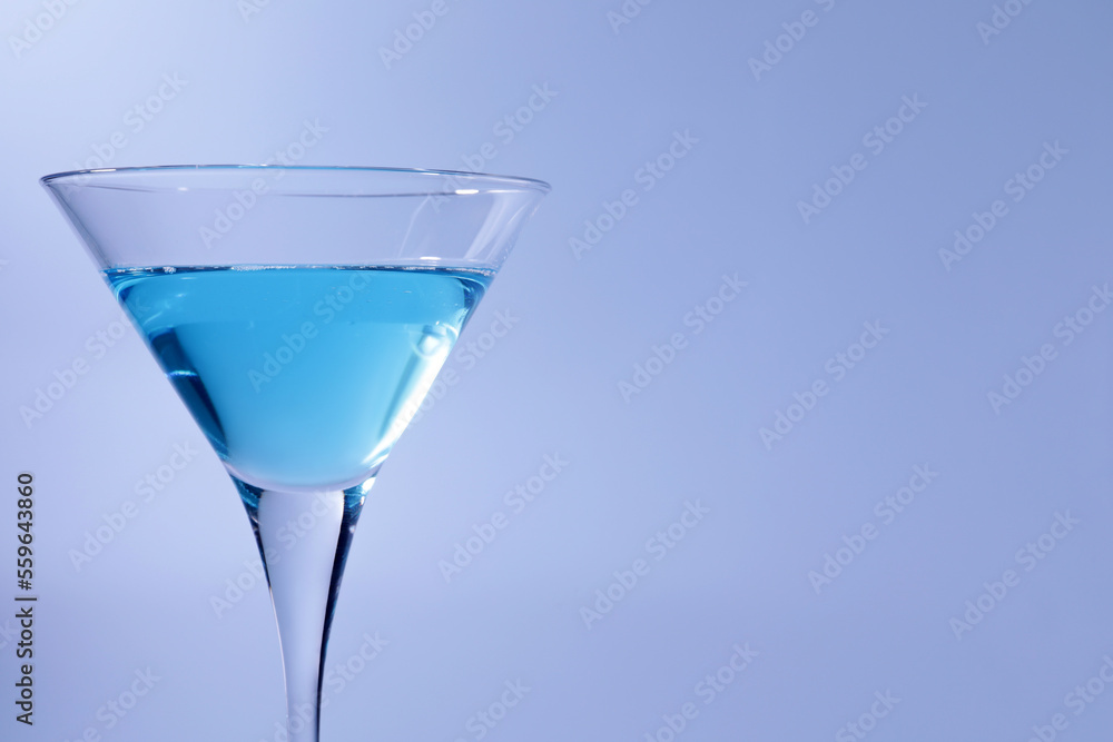 Martini glass with delicious cocktail on light blue background, space for text Martini glass with delicious cocktail on light blue background, space for text