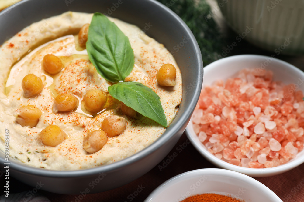 Delicious creamy hummus with chickpeas and ingredients on table, closeup Delicious creamy hummus with chickpeas and ingredients on table, closeup