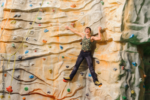 Man climbing on man-made cliff in the sport centre