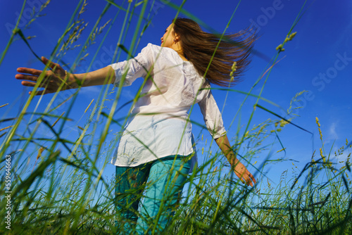 Young woman walk on green field
