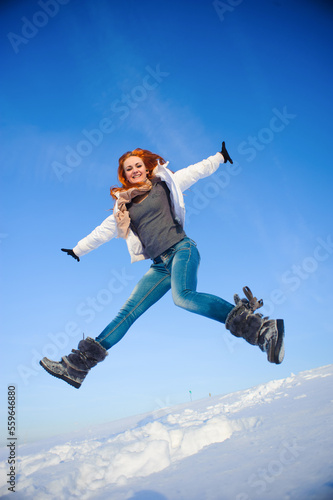 Pretty young woman with red hair take a fun on the snow field