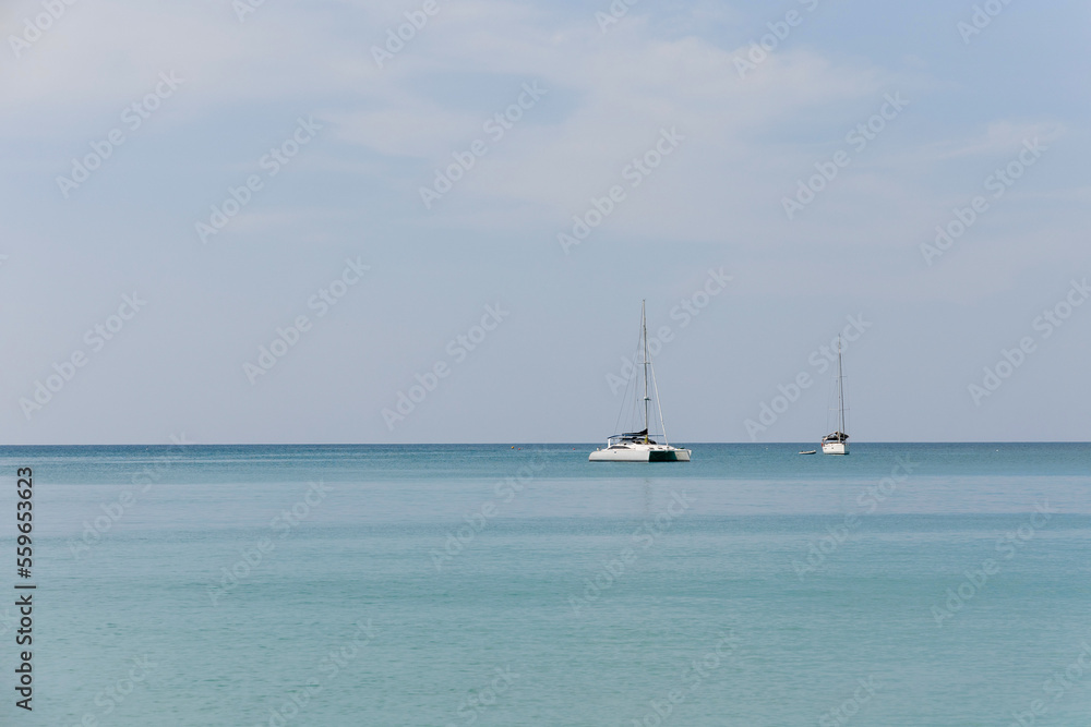 Island and boats on a blue sky with clouds over the sea, wallpaper, background.