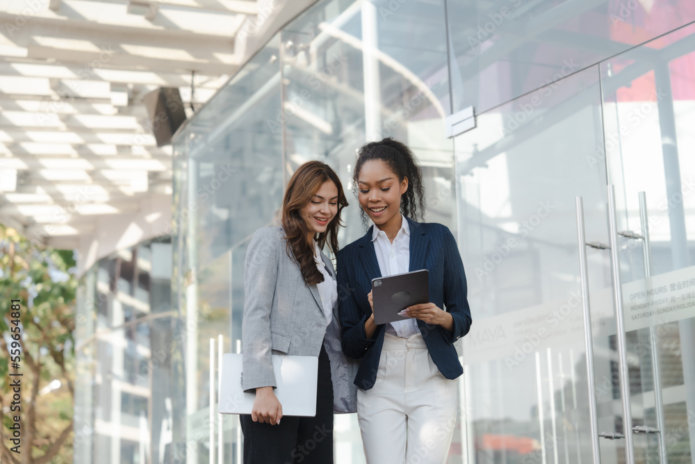 Two asia business women in conversation walking together on city street. Corporate colleagues workmate discussing new project while going to work. business outdoor. Two asia business women in conversation walking together on city street. Corporate colleagues workmate discussing new project while going to work. business outdoor.