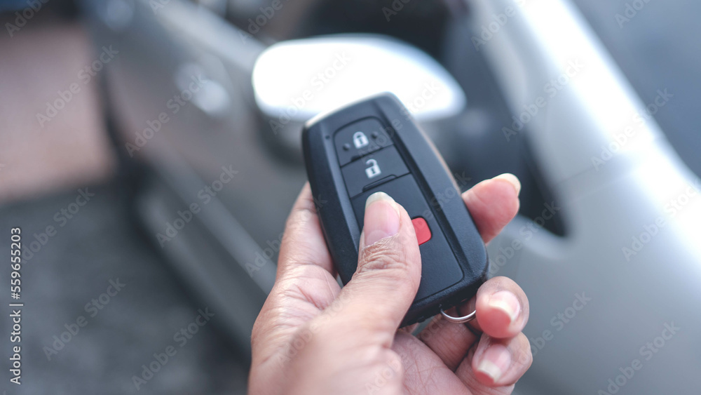 Hand holding car remote control, The back is a blurry car. Buying or selling a car concept. Hand holding car remote control, The back is a blurry car. Buying or selling a car concept.