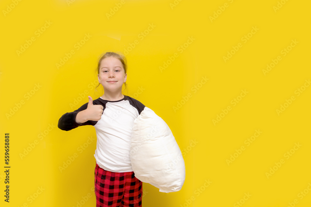 little girl in pajamas and with a pillow on a yellow background shows like little girl in pajamas and with a pillow on a yellow background shows like