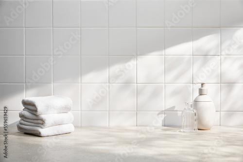front view of bathroom with white tile wall, various bath objects, and sunlight. copy space.