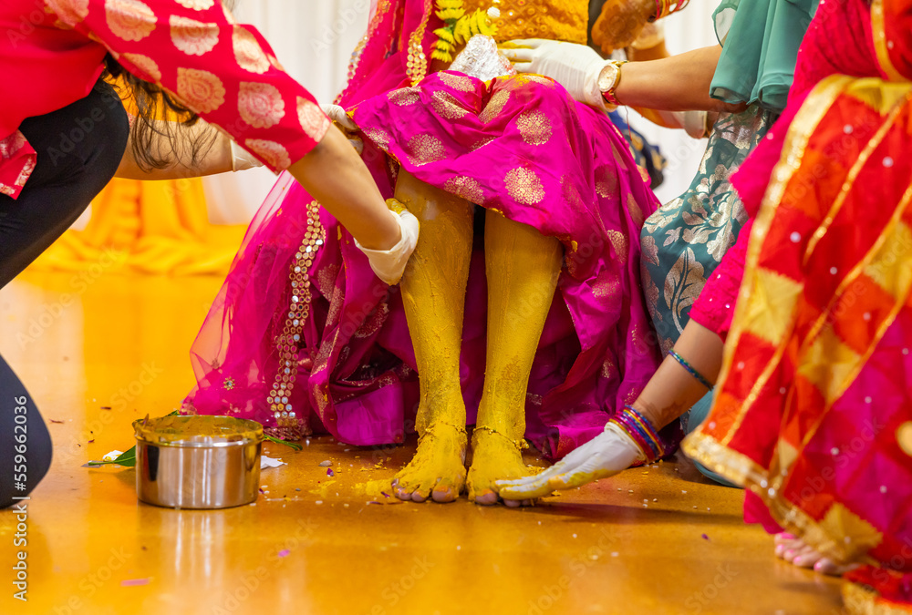 Indian Hindu pre wedding yellow turmeric Haldi ceremony bride's feet close up