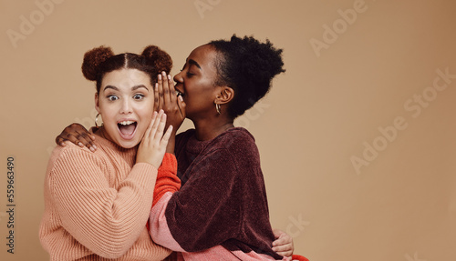 Friends, gossip and women share secret on studio background and product placement mockup. Secrets, rumours and surprise whisper in ear, black woman with happy woman discuss discount sale announcement