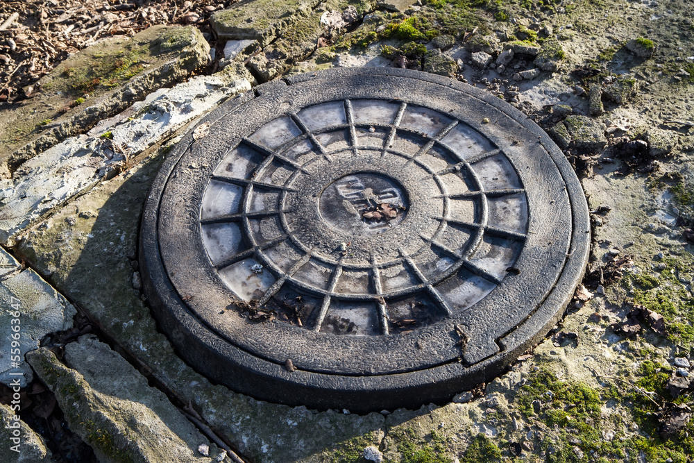 Manhole cover. An old well with a lid.