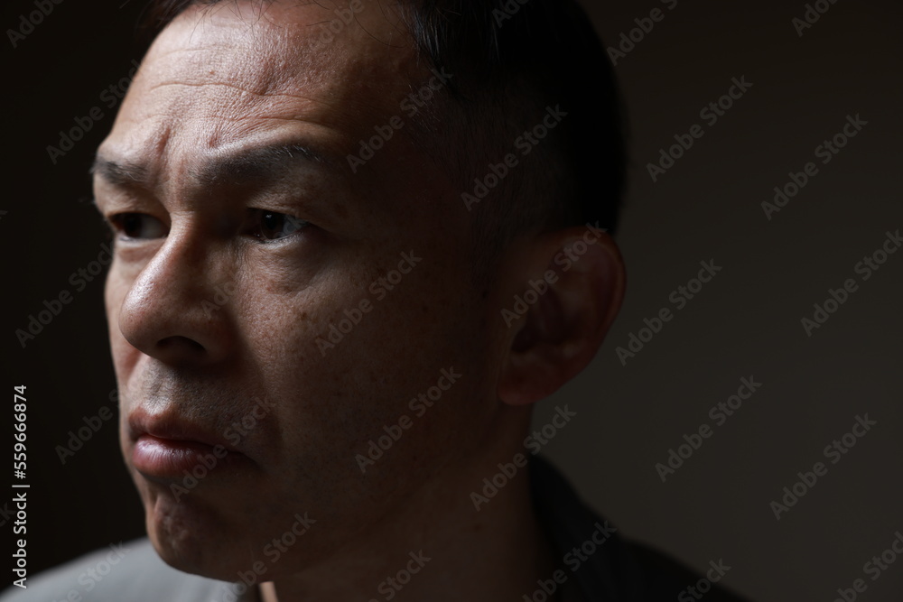 Middle-aged Japanese man in gray casual shirt on gray background. Conceptual image of world peace, stability in daily life, and sustainable living. Middle-aged Japanese man in gray casual shirt on gray background. Conceptual image of world peace, stability in daily life, and sustainable living.