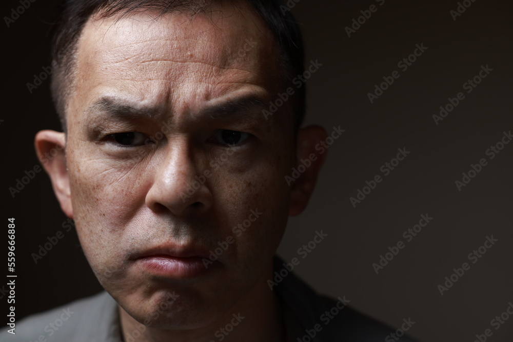 Middle-aged Japanese man in gray casual shirt on gray background. Conceptual image of world peace, stability in daily life, and sustainable living. Middle-aged Japanese man in gray casual shirt on gray background. Conceptual image of world peace, stability in daily life, and sustainable living.