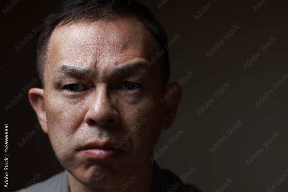 Middle-aged Japanese man in gray casual shirt on gray background. Conceptual image of world peace, stability in daily life, and sustainable living. Middle-aged Japanese man in gray casual shirt on gray background. Conceptual image of world peace, stability in daily life, and sustainable living.