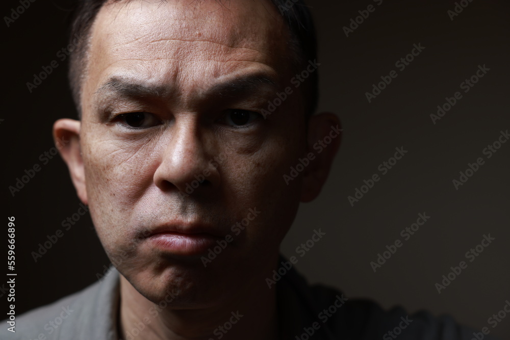 Middle-aged Japanese man in gray casual shirt on gray background. Conceptual image of world peace, stability in daily life, and sustainable living. Middle-aged Japanese man in gray casual shirt on gray background. Conceptual image of world peace, stability in daily life, and sustainable living.