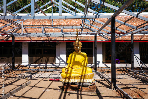 Golden buddha image put on outdoor during temple renovation.