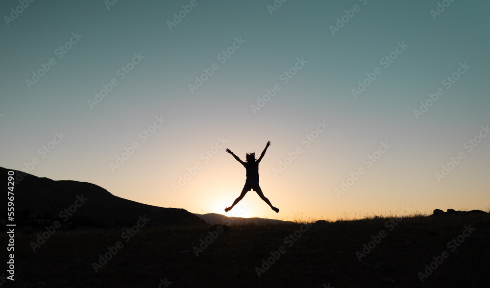 Fototapeta premium girl jumping at sunset in the mountains