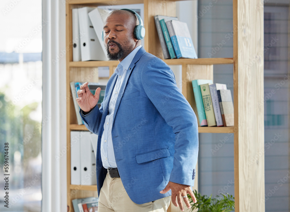 Music, dance and headphones with a business black man manager dancing in his office at work. Wellness, radio and freedom with a senior male worker listening or streaming audio while working - obrazy, fototapety, plakaty 