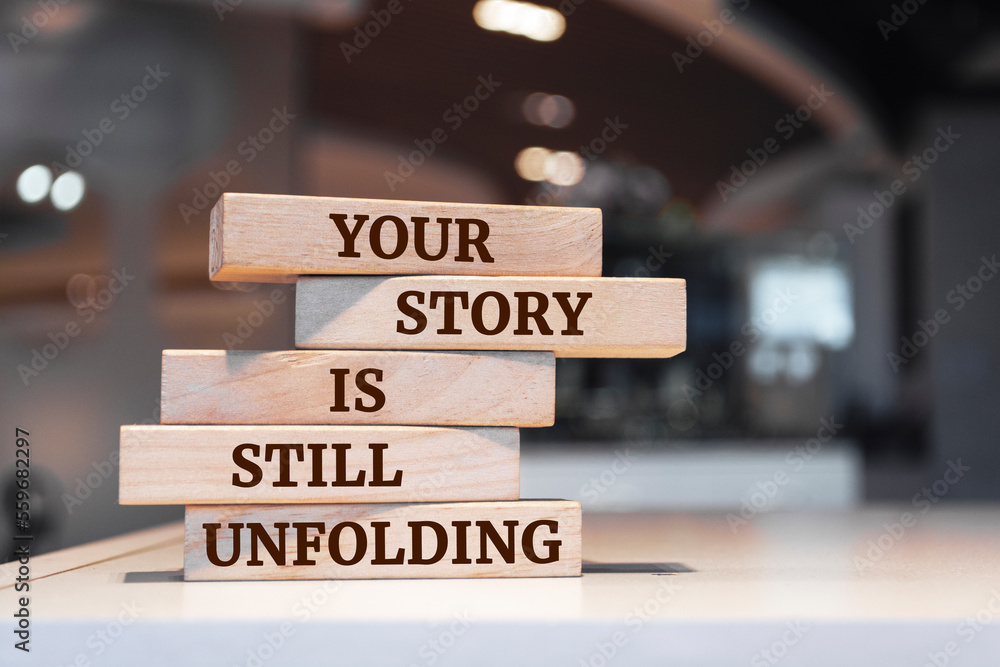 Wooden blocks with words 'Your Story Is Still Unfolding'.