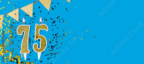 Golden candle number seventy five. Birthday or anniversary card with the inscription 75 on blue background. Anniversary celebration. Banner.