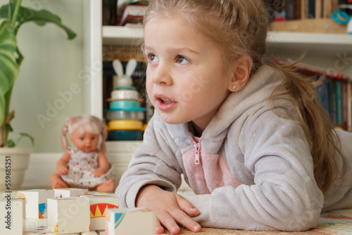 Little cute girl spending time in the playroom, soft focus background