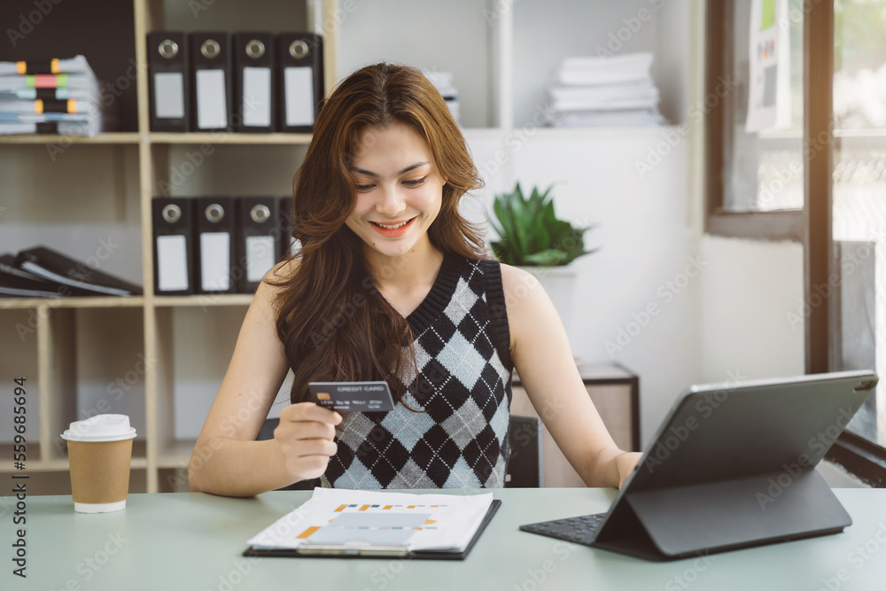 Women use credit cards to pay through tablet at home office. Women use credit cards to pay through tablet at home office.
