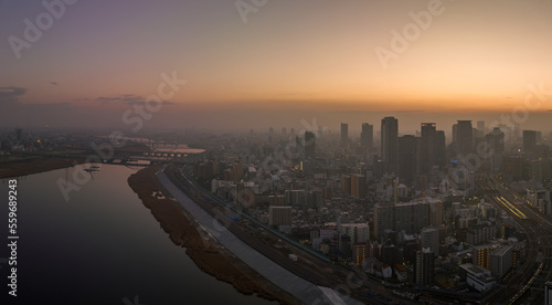 Hazy sunrise over high rise buildings in sprawling city next to river photo
